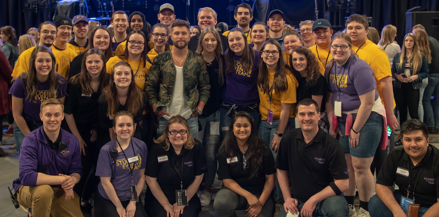 Student Events Team taking group picture with the band