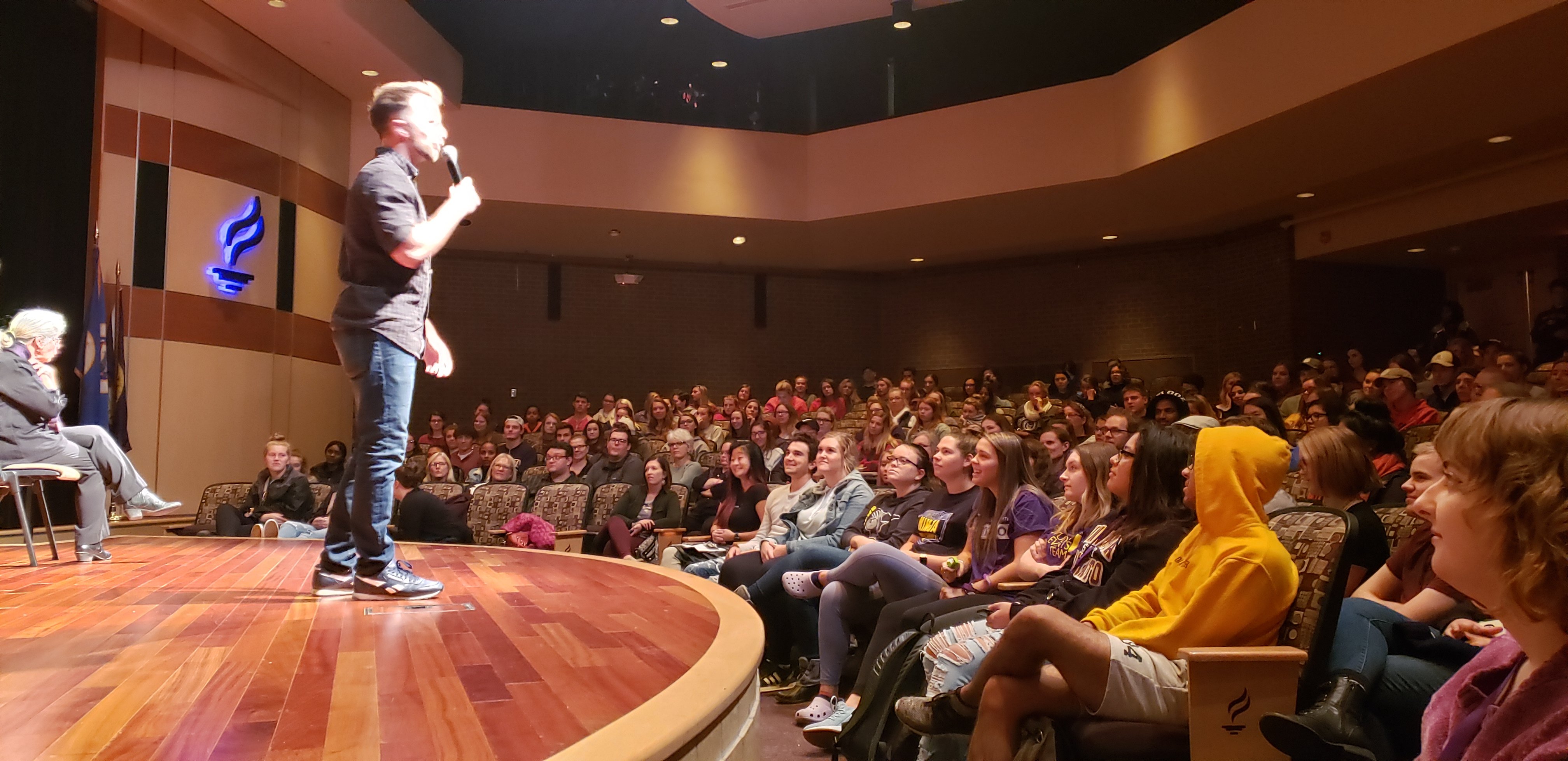 Person on stage speaking to crowd in Ostrander Auditorium