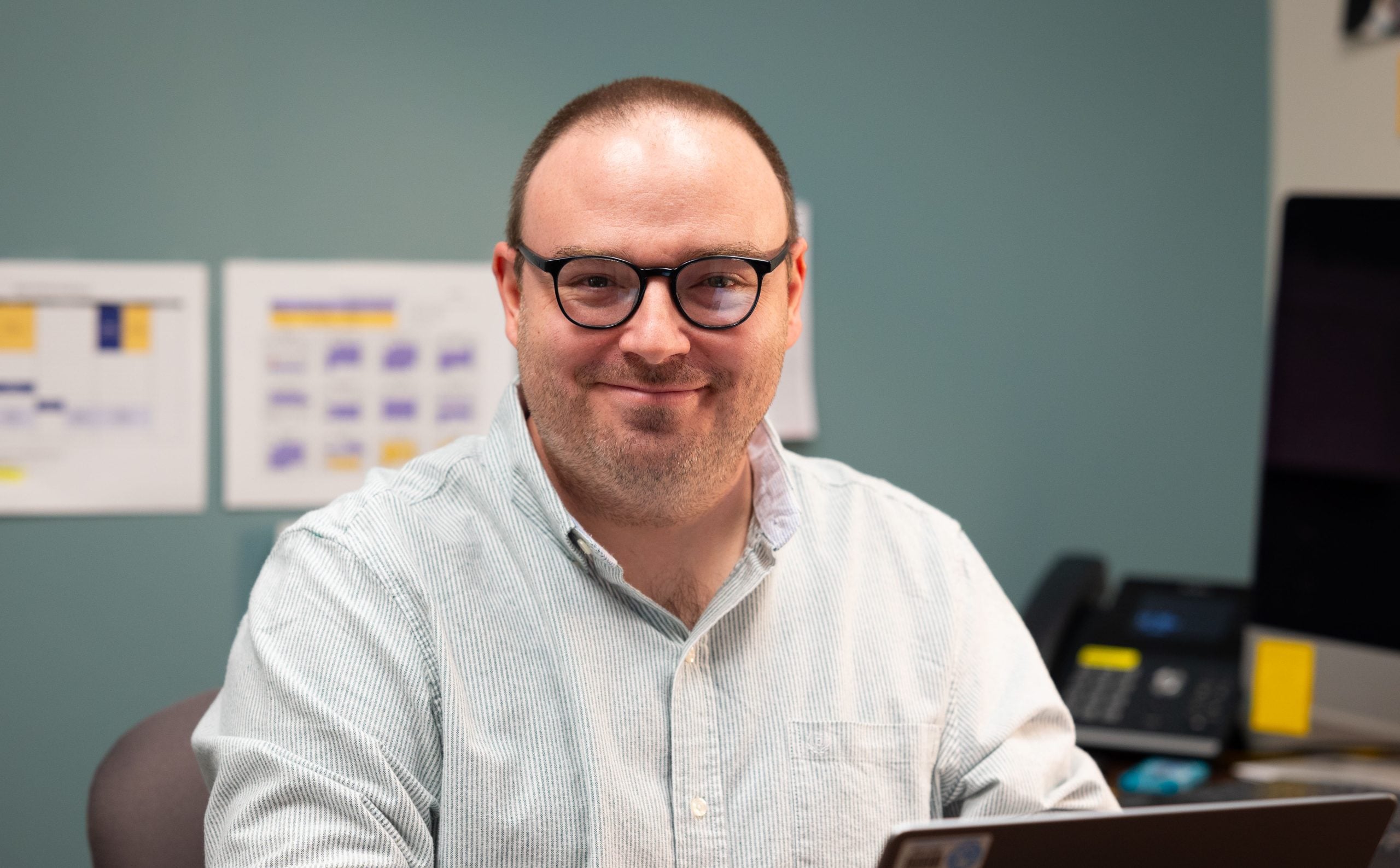 Photo of Aaron Hoy sitting and smiling