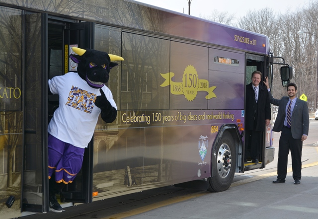 University President Richard Davenport, 2016-17 Student Association President Faical Rayani, and Stomper checked out a replacement bus wrap