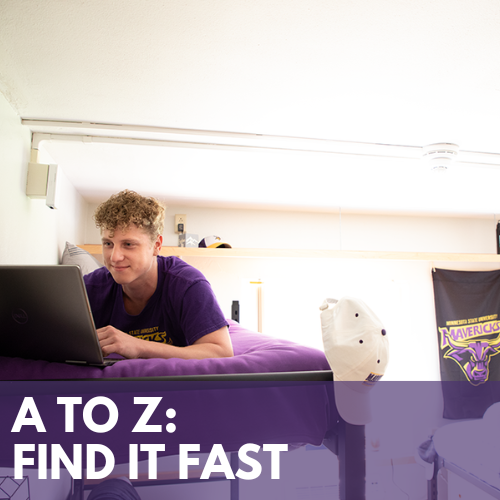 Picture of a student on a bed looking something up on a laptop