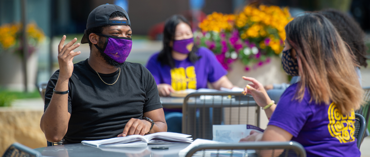Students with their cloth masks on studying outdoors