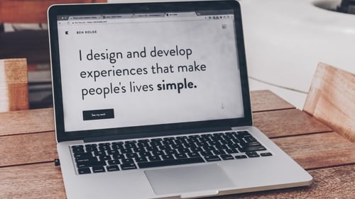 text on a laptop that reads "I design and develop experiences that make people's lives simple."