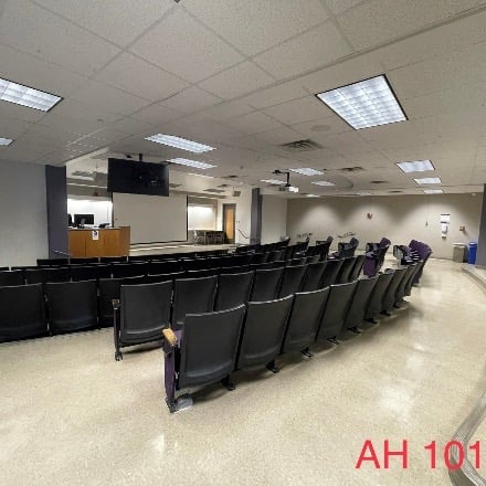 Small Auditorium with whiteboard in front and chairs rising to the back.