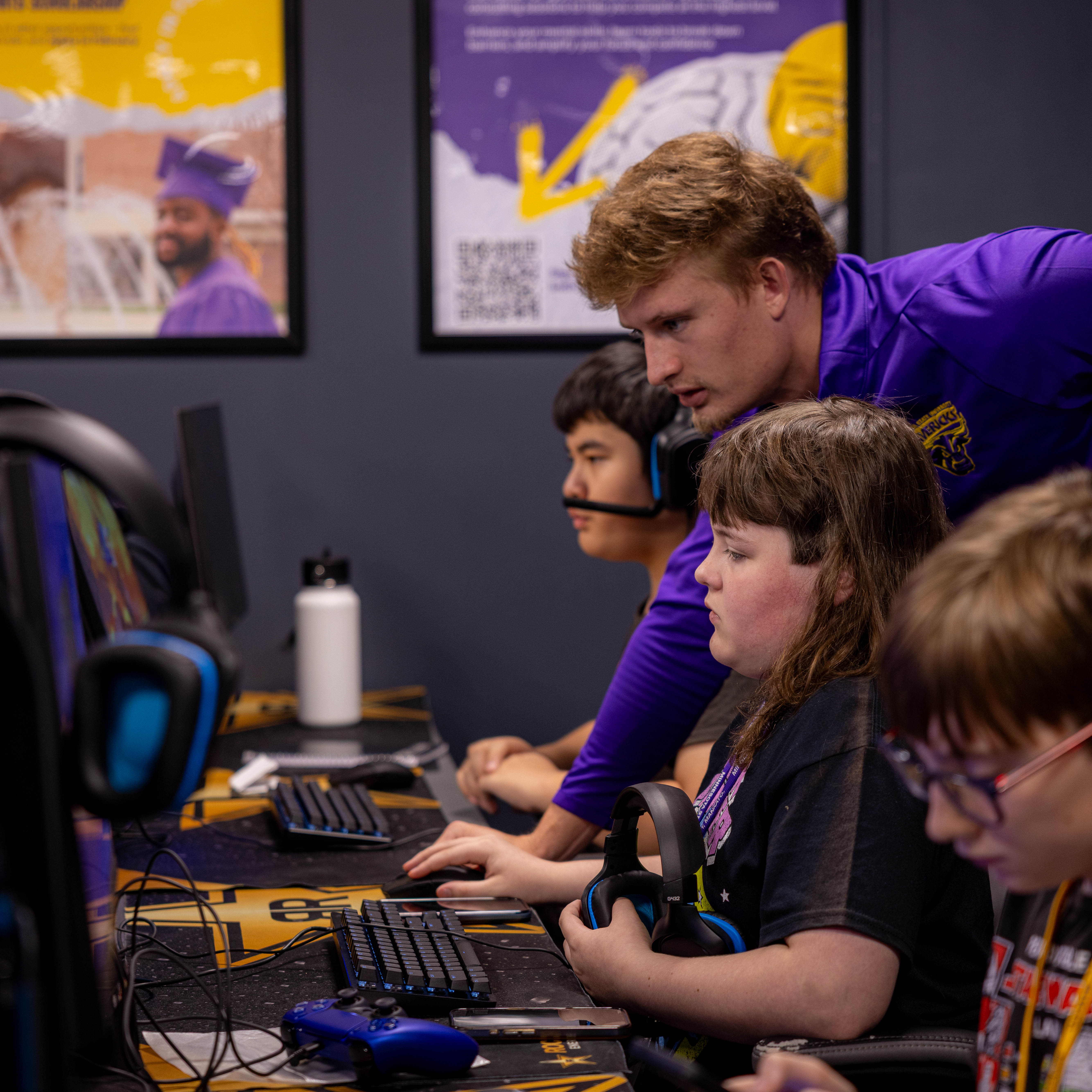 an Esports advisor is helping a young camper on the state of the art Esports equipment