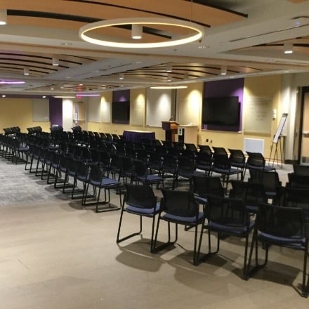 Room with chairs lined up in rows and a podium in front for a speaker.
