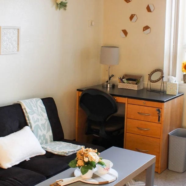 Decorated dorm room with a couch and a desk.