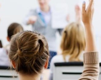 a person raising her hand in a classroom