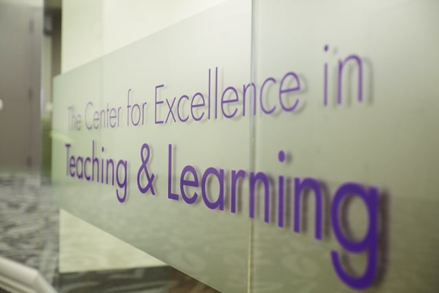 a photo of glass sign that reads Center for Excellence in Teaching and Learning at an angle