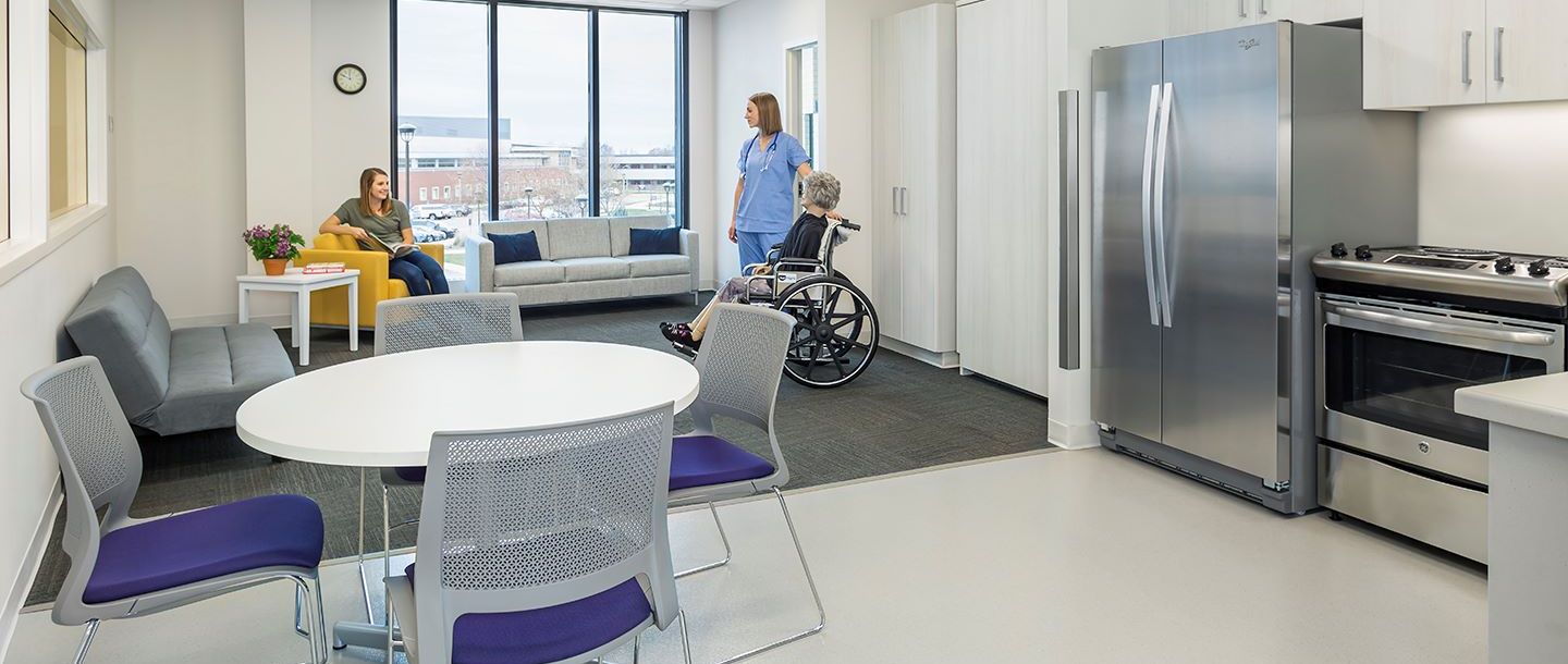 The home health simulation suite is designed to resemble a studio apartment space that includes a kitchen and bathroom, living room area, and a murphy bed