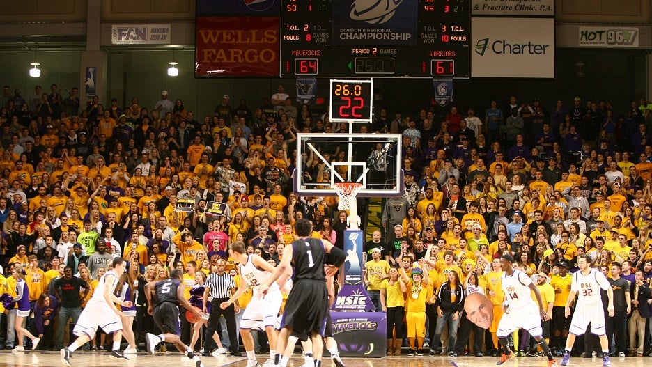 A men's Maverick basketball game with audience in the background