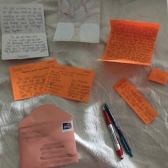 several papers and pens on a bed