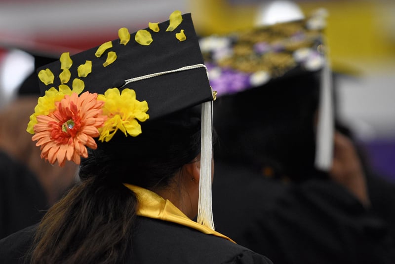 graduate wearing mortarboard that is decorated with flowers
