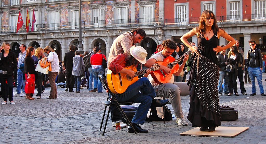 Flamenco dancer and three guitar players perform before a crowd of people