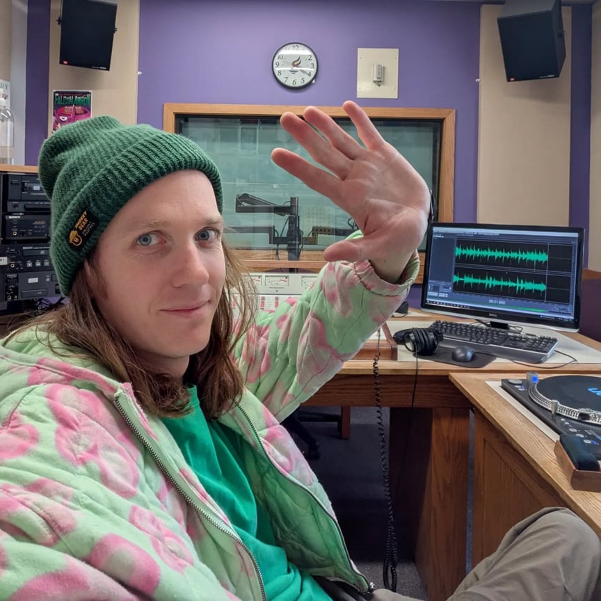 KMSU host Will Bjorndal waving goodbye to the camera in a radio studio