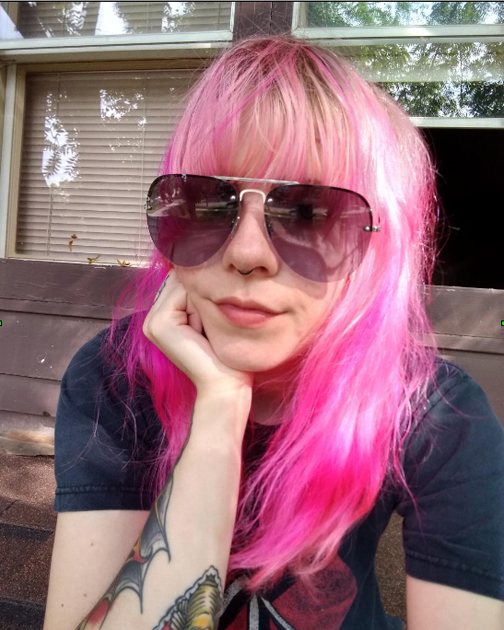 a person with pink hair and sunglasses