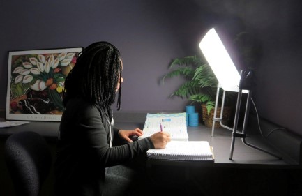 female student reading with bring light