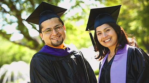 Two students in graduation attire