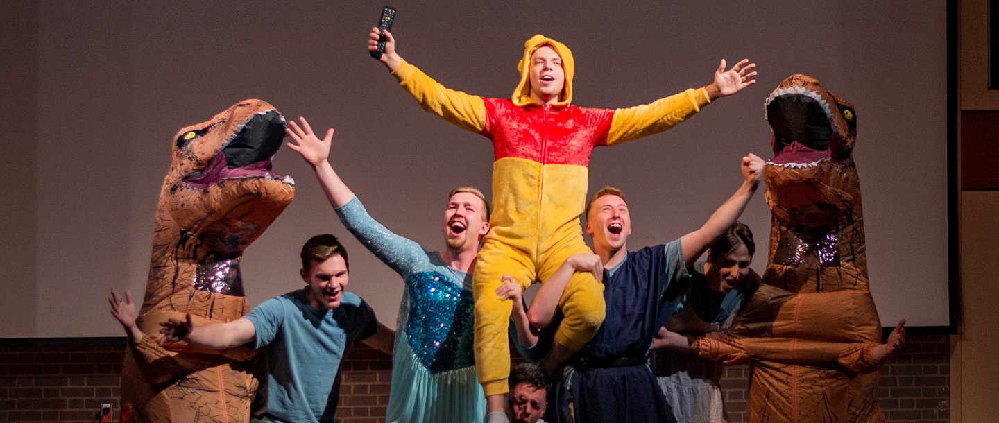 Fraternity member wearing Pooh bear costume on stage