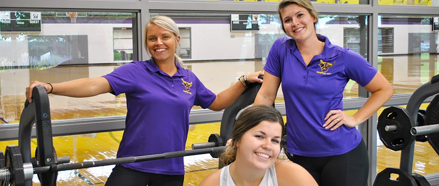 Three women trainers in the Otto Recreation Center weight room