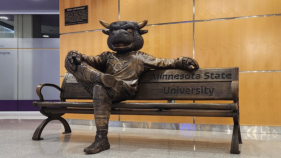 a statue of a bull sitting on a bench