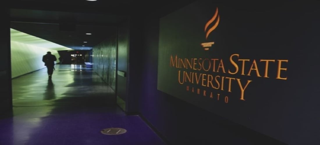 Minnesota State University, Mankato logo at the entrance of the CSU tunnel and a person walking down the tunnel
