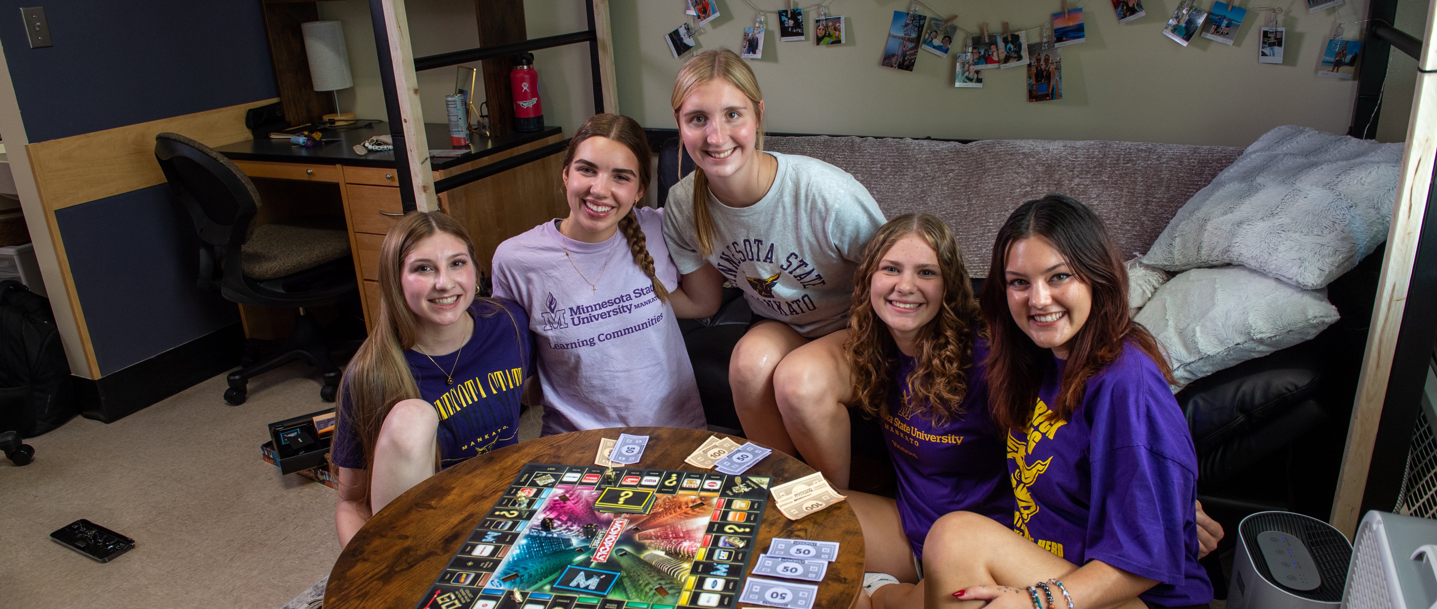 Students posing around a card table