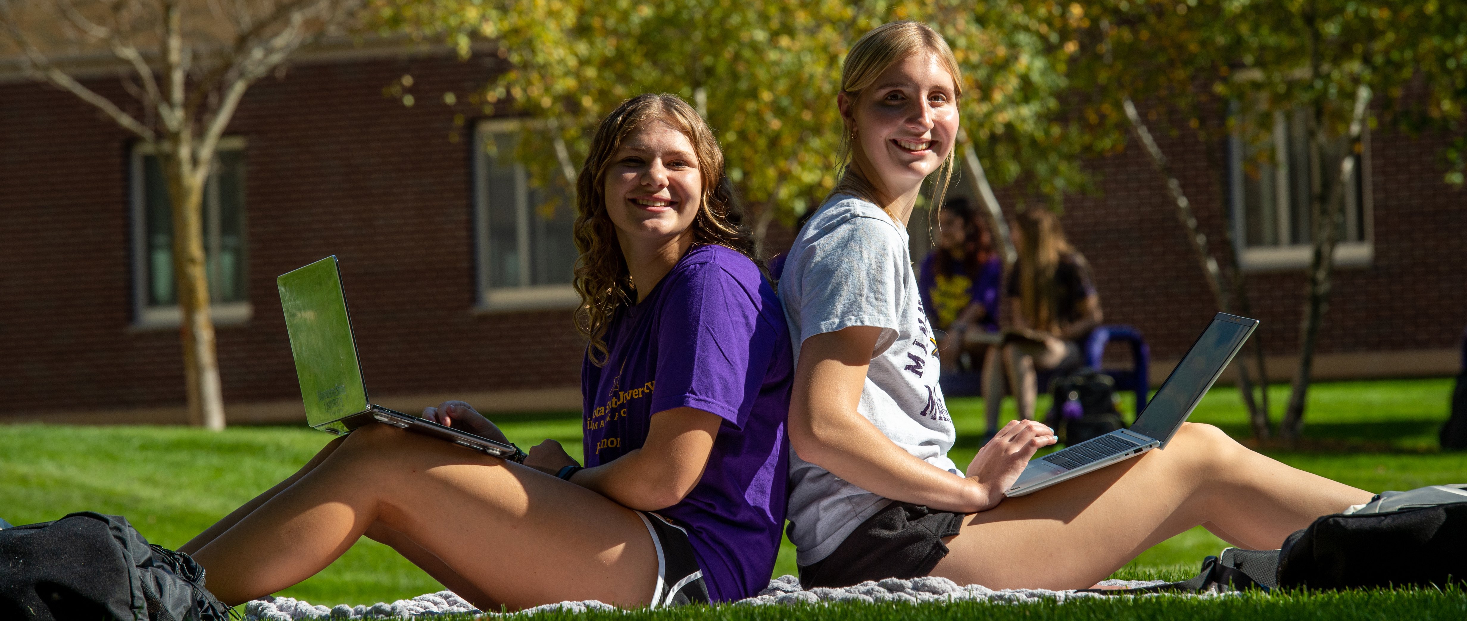 Two girls posing for camera on lawn