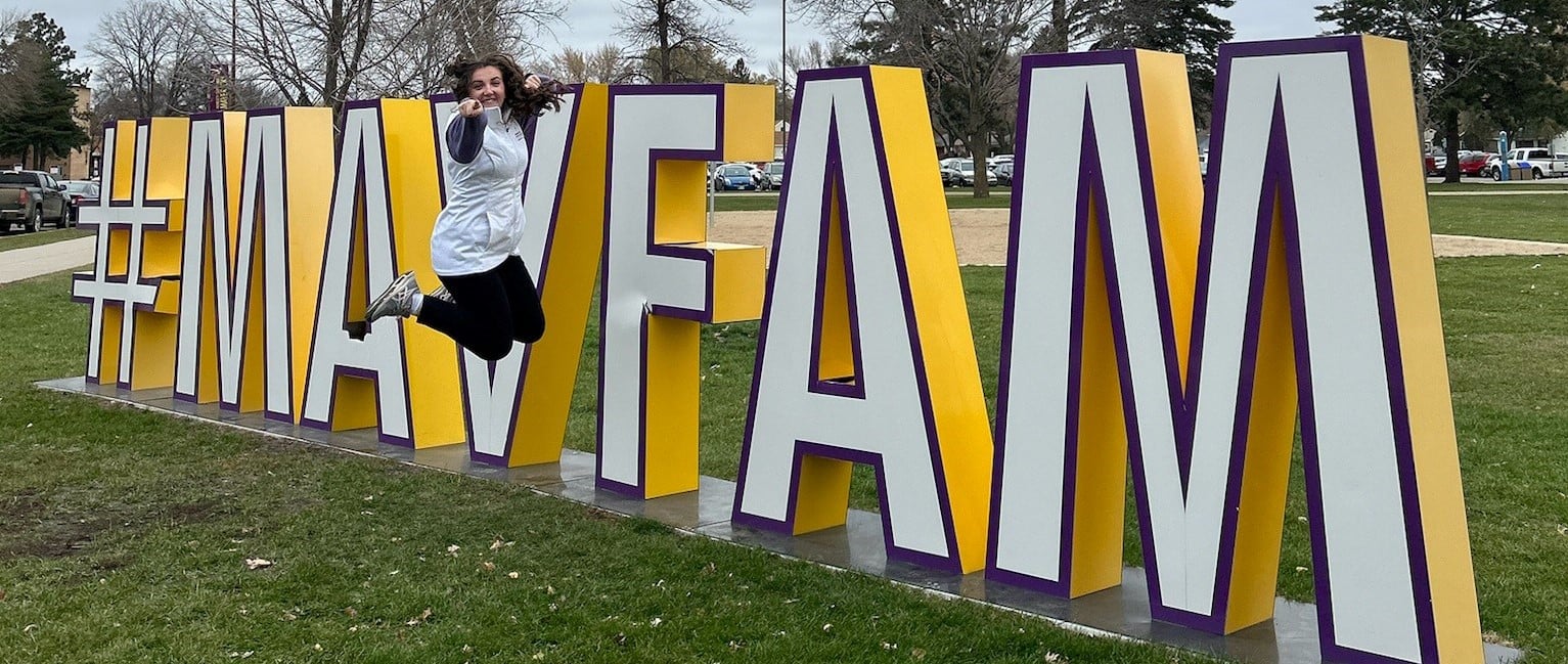 a person jumping in the air in front of a large sign