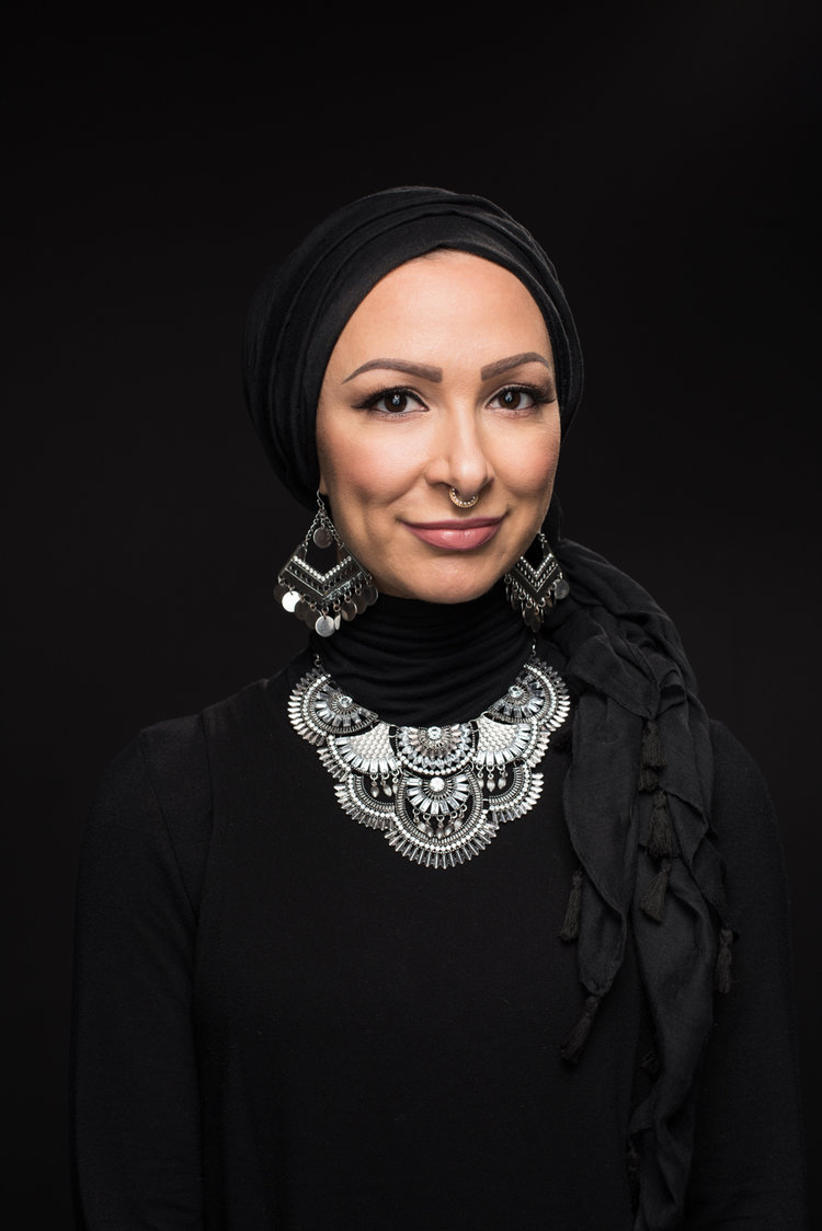 a person wearing a black dress and a black scarf