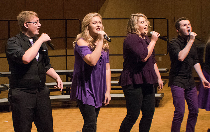 a group of women singing into microphones